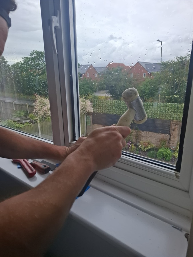 Glazer fitting replacement double glazing beads into a white uPVC window in Essex