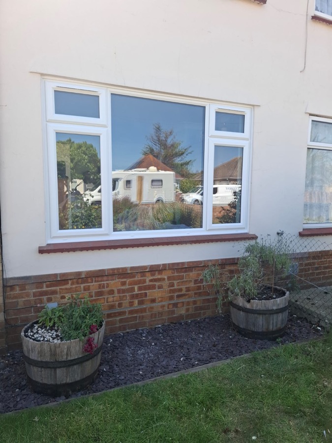 White uPVC casement windows fitted to a red-brick Essex home